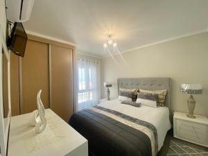 ein Schlafzimmer mit einem Bett und einem TV in der Unterkunft casa hilario in Nazaré