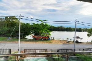 un bateau assis sur le côté d'un lac dans l'établissement Kayak D'bali Homestay, à Pasir Puteh