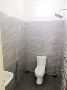 a bathroom with a white toilet and a sink at YY Homestay Pasir Mas in Pasir Mas