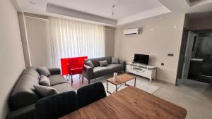 a living room with a couch and a table at Selinti City Tatil Evleri1&1 in Gazipasa