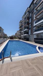 a large swimming pool in front of a building at Selinti City Tatil Evleri1&1 in Gazipasa