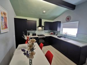 cocina con mesa blanca y sillas rojas en Large 5 Bed House, 9 Beds + Parking + 3 bathrooms, en Wirral