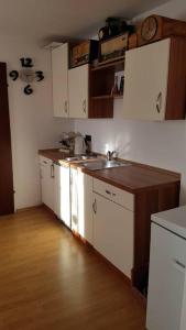 a kitchen with white cabinets and a wooden floor at Kellergeschoss Wohnung Moto GP Wochenende in Kraubath an der Mur