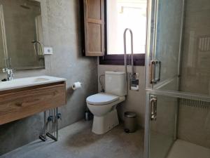 a bathroom with a toilet and a sink and a shower at Apartamentos Villa de Panes - La Bolera in Panes