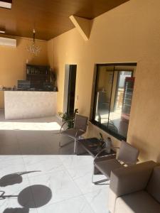 a lobby with two chairs and a counter in a building at Hotel Bee's Sorriso in Sorriso