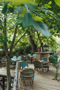 un montón de mesas y sillas en una terraza de madera en ALANYA BUNGALOW EVLERİ / RESTAURANT en Asmaca