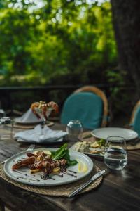 einem Holztisch mit einem Teller Essen drauf in der Unterkunft ALANYA BUNGALOW EVLERİ / RESTAURANT in Asmaca