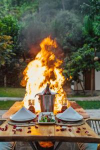 einem Holztisch mit einem Feuer im Hintergrund in der Unterkunft ALANYA BUNGALOW EVLERİ / RESTAURANT in Asmaca