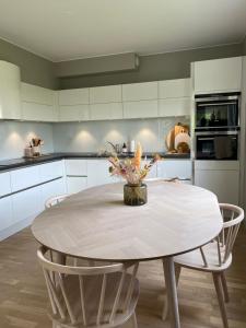 a kitchen with a round table and chairs in a kitchen at Moderne leilighet, 3 sov, parkering. in Trondheim
