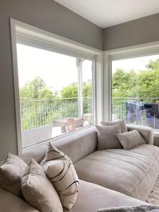 a living room with a couch and a large window at Moderne leilighet, 3 sov, parkering. in Trondheim +7 photos