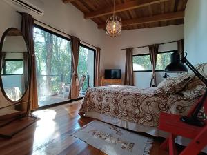 Schlafzimmer mit einem Bett und großen Fenstern in der Unterkunft Vista al Rio Arami 