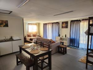 a living room with a couch and a table at Cozy Cabin Country Cottage in Skeerpoort