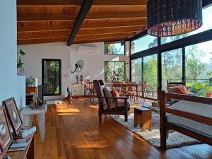ein Wohnzimmer mit Holzböden und großen Fenstern in der Unterkunft Vista al Rio Arami 