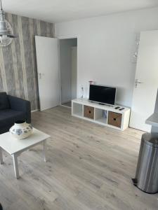 sala de estar con TV, sofá y mesa en Apartment at the Beach en Noordwijk