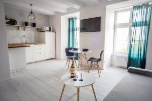 トルンにあるPrzytulny Apartament przy Starym Mieścieのテーブルと椅子のあるキッチンとリビングルーム +19枚の写真