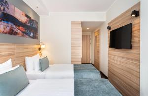 A television and/or entertainment centre at Leonardo Boutique Hotel Linz City Center