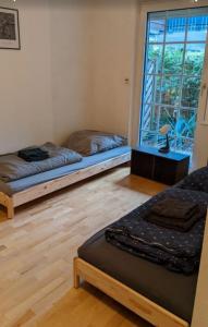 zwei Betten in einem Zimmer mit Fenster in der Unterkunft Schöne Gartenwohnung Düsseldorf in Düsseldorf