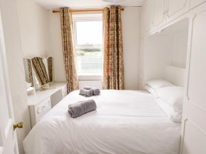 um quarto com uma cama branca e toalhas em Churchfield House em Ballina