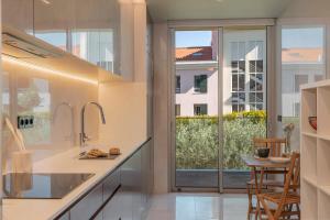 a kitchen with white countertops and a view of a building at Savoy Residence Casa Branca II by An Island Apart in Funchal +19 photos