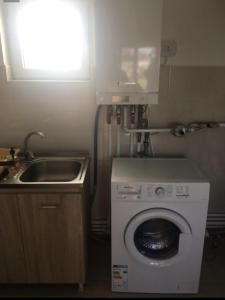 a small kitchen with a washing machine and a sink at Vila Mara in Costinesti
