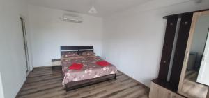a bedroom with a bed with red pillows on it at Vila Mara in Costinesti