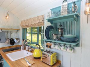 uma cozinha com um lavatório e uma bancada em Two Moors Shepherds Hut em Exeter