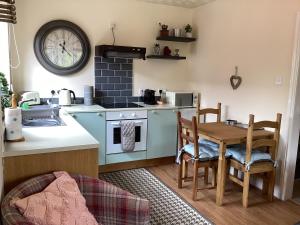 a kitchen with a table and a sink and a stove at The Annex at The Croft in Kingsley