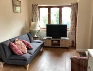 a living room with a couch and a television at The Annex at The Croft in Kingsley