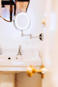 lavabo con espejo de aumento en la pared en Thomas Telford Lettings - Luxurious Interiors and Seaviews en Halistra