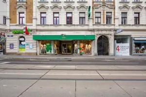 un magasin dans une rue en face d'un bâtiment dans l'établissement FRO-MEDIA - Streetside Room 2 - Community Space, à Vienne
