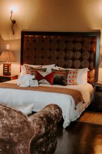 um quarto com uma cama grande e uma grande cabeceira. em Matingwe Lodge em Vaalwater