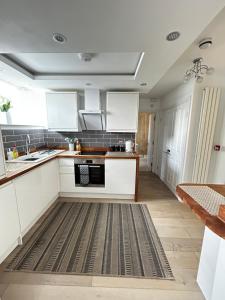 uma cozinha com armários brancos e um tapete em Homely Beachside Apartment in Newquay Town Centre! em Newquay