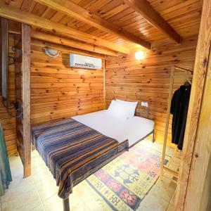 een slaapkamer in een houten hut met een bed bij Tartaruga Boutique Hotel & Bungalows in Sile