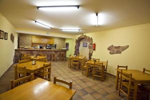 a restaurant with wooden tables and chairs and a counter at Hospedería Las Calzadas in San Vicente de la Barquera