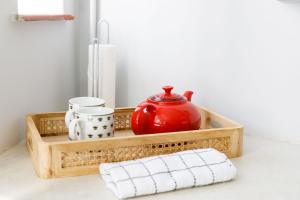 a tray with a red tea pot and a towel at Snowdrop Cottage in Ditchling