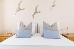 sypialnia z białym łóżkiem z niebieskimi poduszkami w obiekcie Snowdrop Cottage w mieście Ditchling