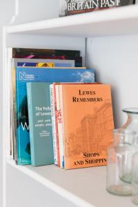 a group of books sitting on a shelf at Snowdrop Cottage in Ditchling