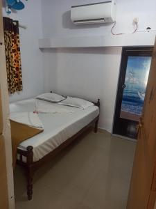 Pallipuram的住宿－EDEN BEACH VILLA，卧室配有一张带空调的壁床。