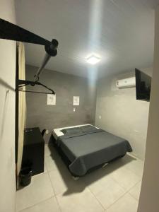 a bedroom with a bed in a room with a spotlight at Hotel Bee's Sorriso in Sorriso