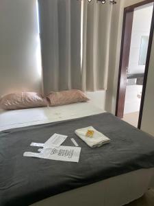 a bed with two towels on top of it at Hotel Bee's Sorriso in Sorriso