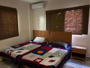 1 dormitorio con 1 cama con edredón en See view rooftop apartment en Gaza