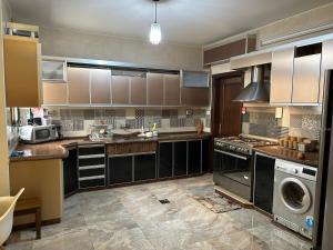 a large kitchen with a sink and a dishwasher at See view rooftop apartment in Gaza