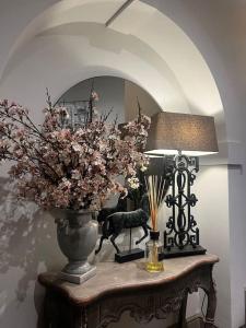 uma mesa com um vaso de flores e um candeeiro em Luxury apartment Berkshire em Binfield