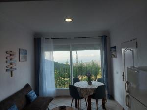 uma sala de jantar com uma mesa e uma grande janela em Apartamentos CHRISTINA em Benicàssim
