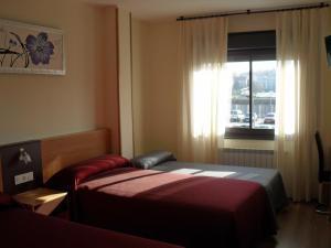 a hotel room with two beds and a window at Peregrino in Pontevedra