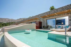 a house with a swimming pool with a slide at Lindos Bay Hotel in vlicha