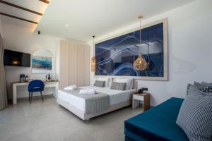 sypialnia z białym łóżkiem i niebieskim krzesłem w obiekcie Lindos Bay Hotel w mieście vlicha