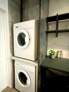 a laundry room with a washer and a washing machine at Happy Living Hostel in Wrocław