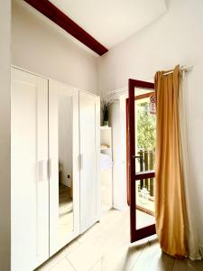 Zimmer mit weißen Schränken und einem Spiegel in der Unterkunft Happy Living Hostel in Breslau