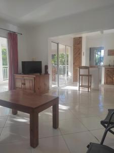 a living room with a coffee table and a tv at Caoba in Las Terrenas